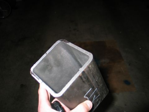 1984 Ford Bronco - A metal tube with visible cut edges is held by a hand, with partial text visible on its side.