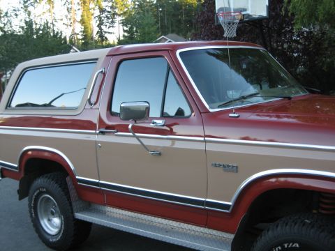 1984 Ford Bronco - This two-tone 1984 Ford Bronco features a prominent side profile with classic chrome accents.