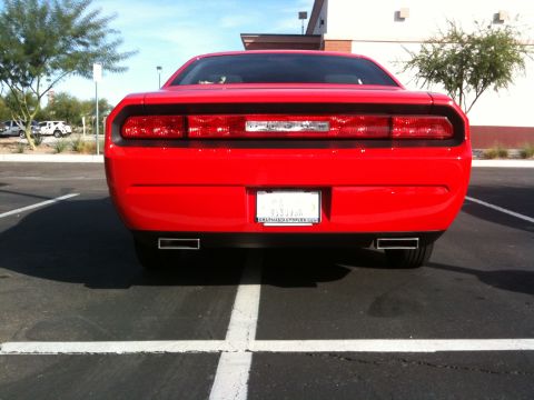 2010 Dodge Challenger - Rear view of a red Dodge Challenger showing its taillights and dual exhaust pipes.
