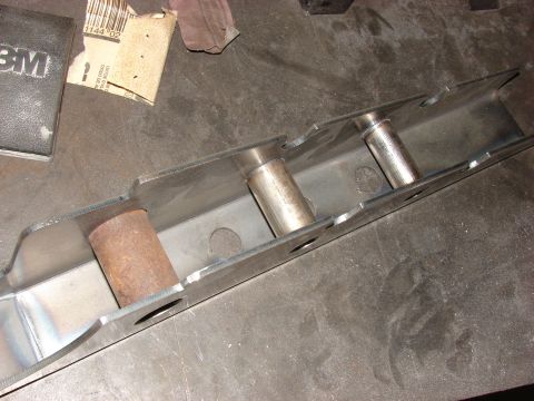 1996 Jeep Grand Cherokee - Metal bracket with pins, likely a custom part, on a workbench with sandpaper and 3M products.