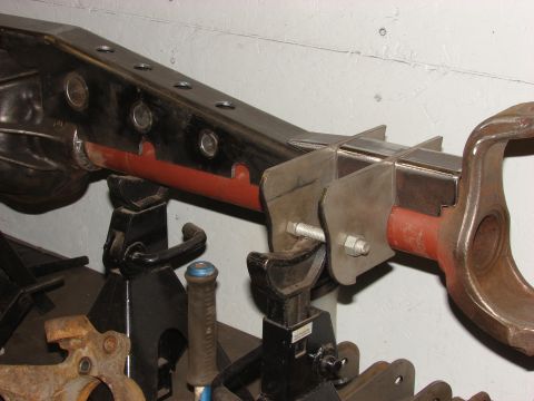 1996 Jeep Grand Cherokee - A close-up view of a modified axle assembly, supported by jack stands, with visible metalwork and red painted sections.