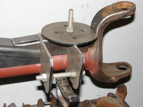 1996 Jeep Grand Cherokee - A close-up view of a custom-fabricated metal bracket attached to a vehicle's suspension system.
