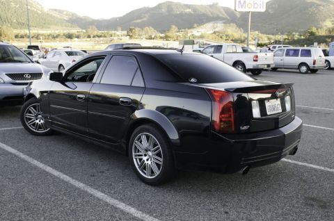 2006 Cadillac STS - Black Cadillac sedan with a V-logo on the rear fender is parked in a lot with other vehicles.