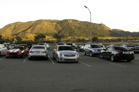 2006 Cadillac STS - Several cars are parked in a lot, including a silver 2006 Cadillac STS and a black Cadillac CTS.