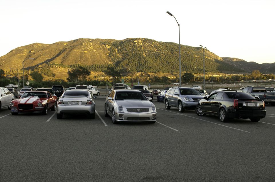 Silver 2006 Cadillac STS parked in a lot with a red Camaro and black Cadillac CTS