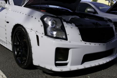 2006 Cadillac STS - This heavily modified vehicle features a unique riveted exterior and its hood is open, revealing the engine bay.