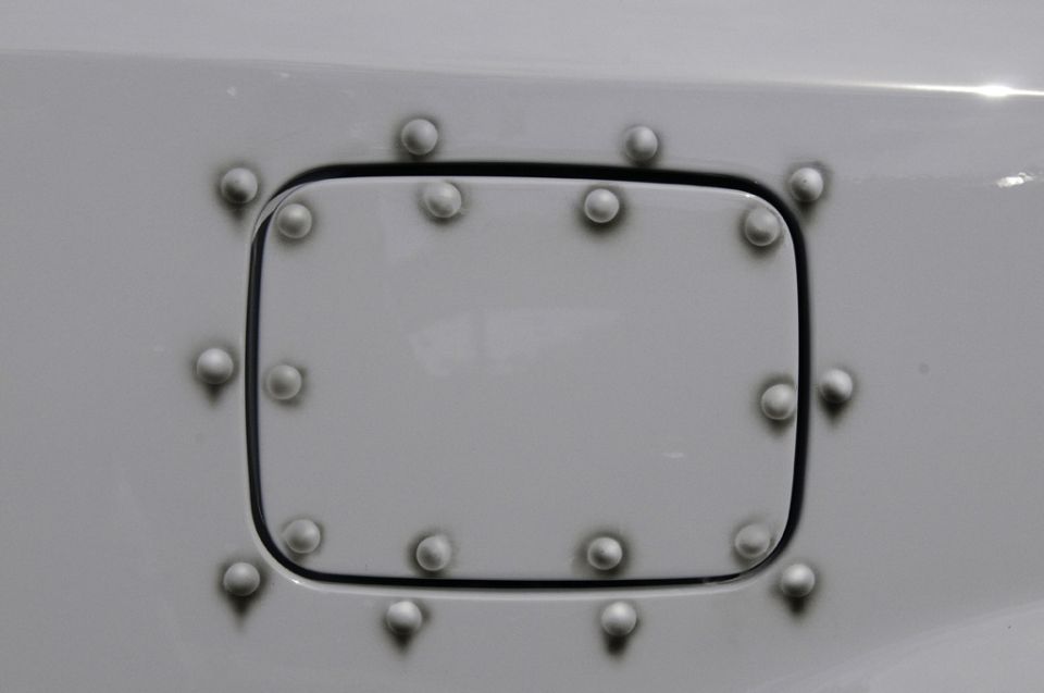 Gray fuel door with faux rivets on a vehicle