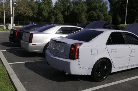 2006 Cadillac STS - A white 2006 Cadillac STS with unique riveted body panels is parked alongside other Cadillacs.