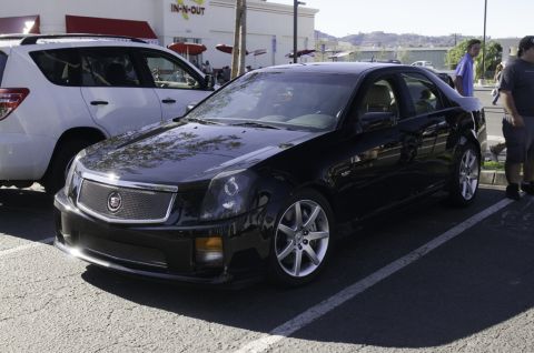 2006 Cadillac STS - A black 2006 Cadillac STS sedan is parked in a lot, with a white SUV to its left.
