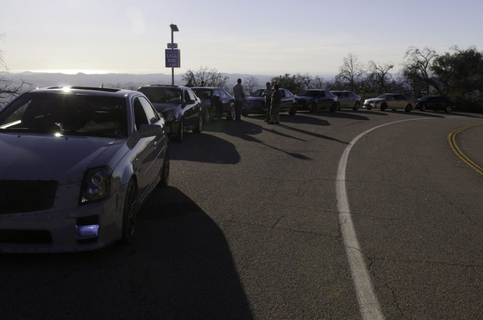 White Cadillac CTS with sunroof, front quarter view, parked on a winding road