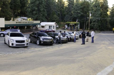2006 Cadillac STS - Several Cadillac sedans, including a white 2006 STS, are parked outside Mother's Kitchen Restaurant.