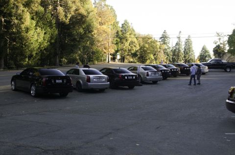 2006 Cadillac STS - A line of Cadillac CTS sedans are parked in a lot, with a pickup truck visible in the background.