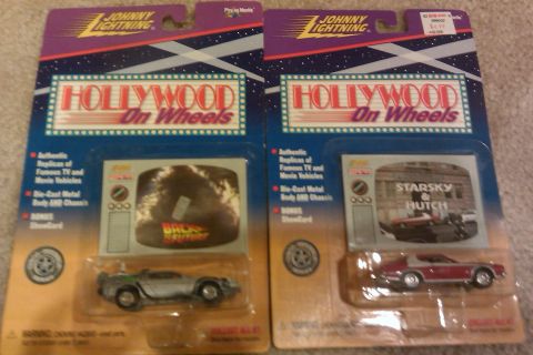 2010 Mitsubishi Outlander - Two collectible toy car packages are displayed, each representing a famous movie vehicle.