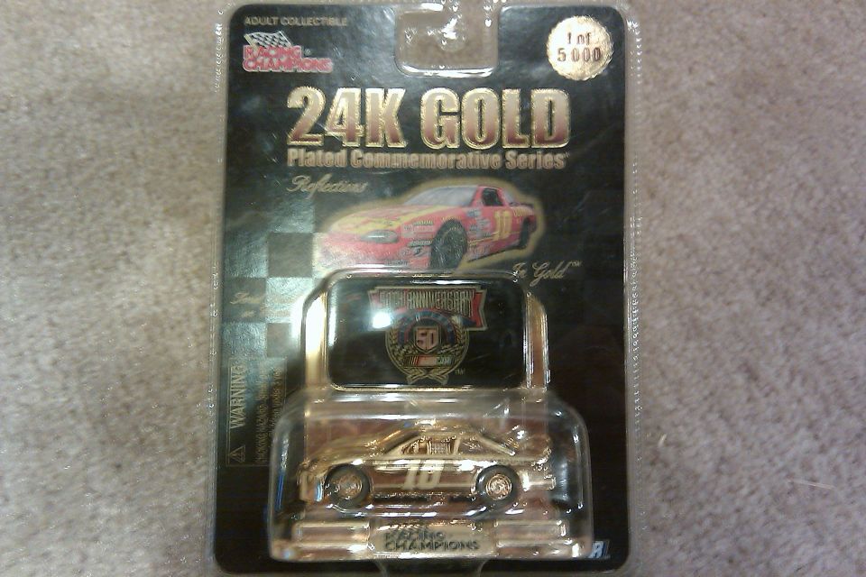 Gold 1:64 scale diecast race car in "24K Gold Plated Commemorative Series" packaging
