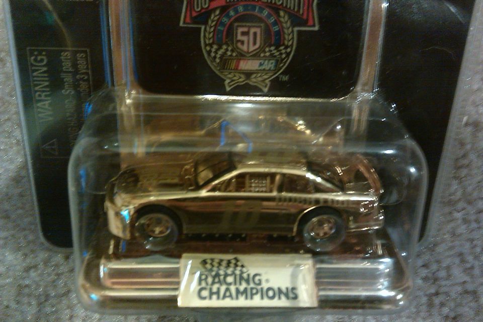 Die-cast toy stock car in plastic packaging, labeled Racing Champions