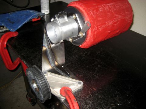 1996 Ford Bronco - A custom air intake assembly, including a throttle body and red air filter, is clamped to a workbench.
