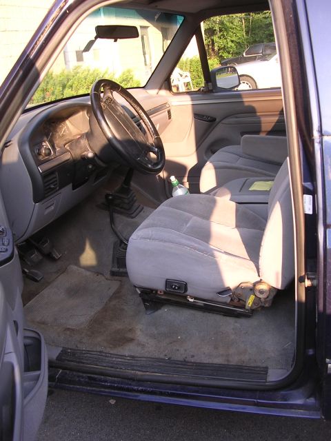 1995 Ford Bronco - The interior of a Ford Bronco, with a second vehicle visible outside the passenger side window.