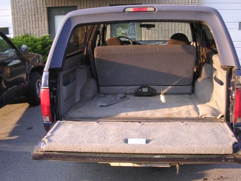 1995 Ford Bronco - Rear view of a 1995 Ford Bronco's interior, showing the cargo space and folded rear seats.