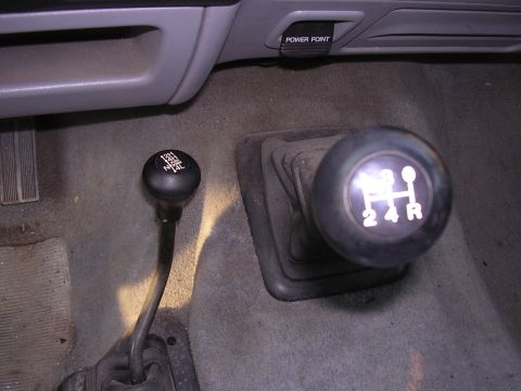 1995 Ford Bronco - The interior shows the transmission shifter and a separate transfer case shifter for 4WD engagement.