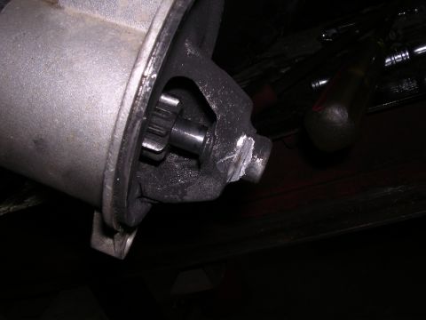 1995 Ford Bronco - Close-up of a vehicle starter motor and its engagement gear.