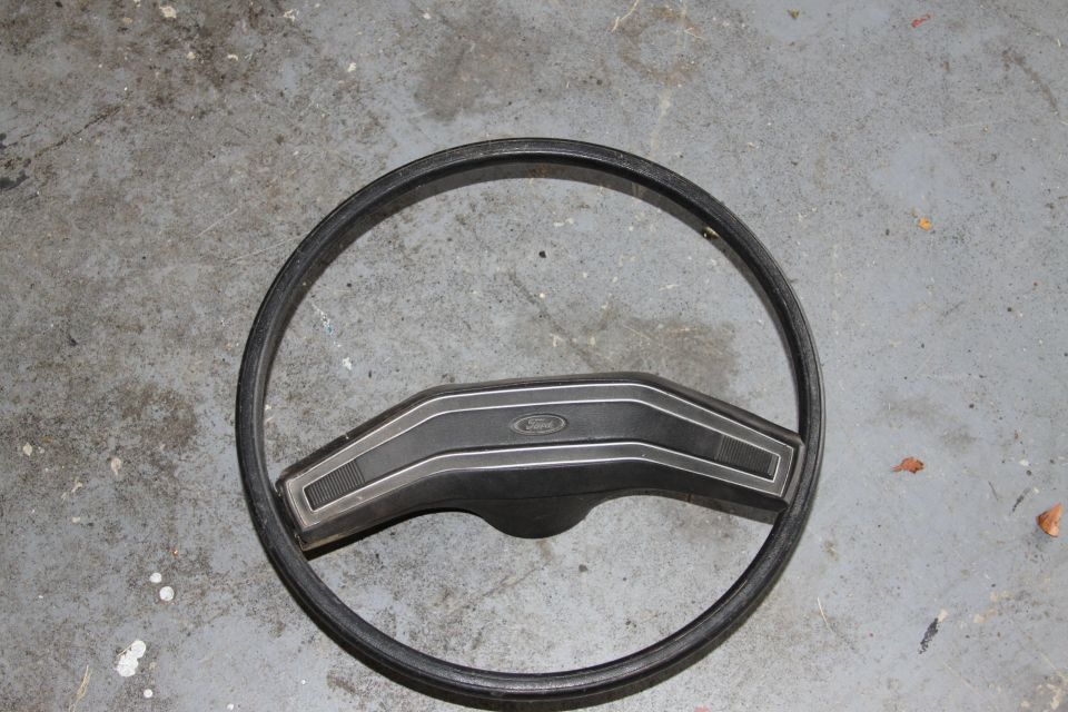 Ford steering wheel with a black rim and a black center hub with silver trim