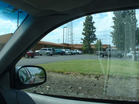 1999 Ford Crown Victoria - A view from inside a vehicle shows a parking lot with several cars and a pickup truck under a cloudy sky.