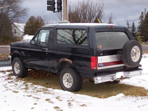 1996 Ford Bronco - Rear view of a black 1996 Ford Bronco SUV parked outside in a snowy environment.