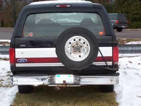 1996 Ford Bronco - This Ford Bronco features a spare tire on the rear door and a two-tone paint scheme with red and white stripes.