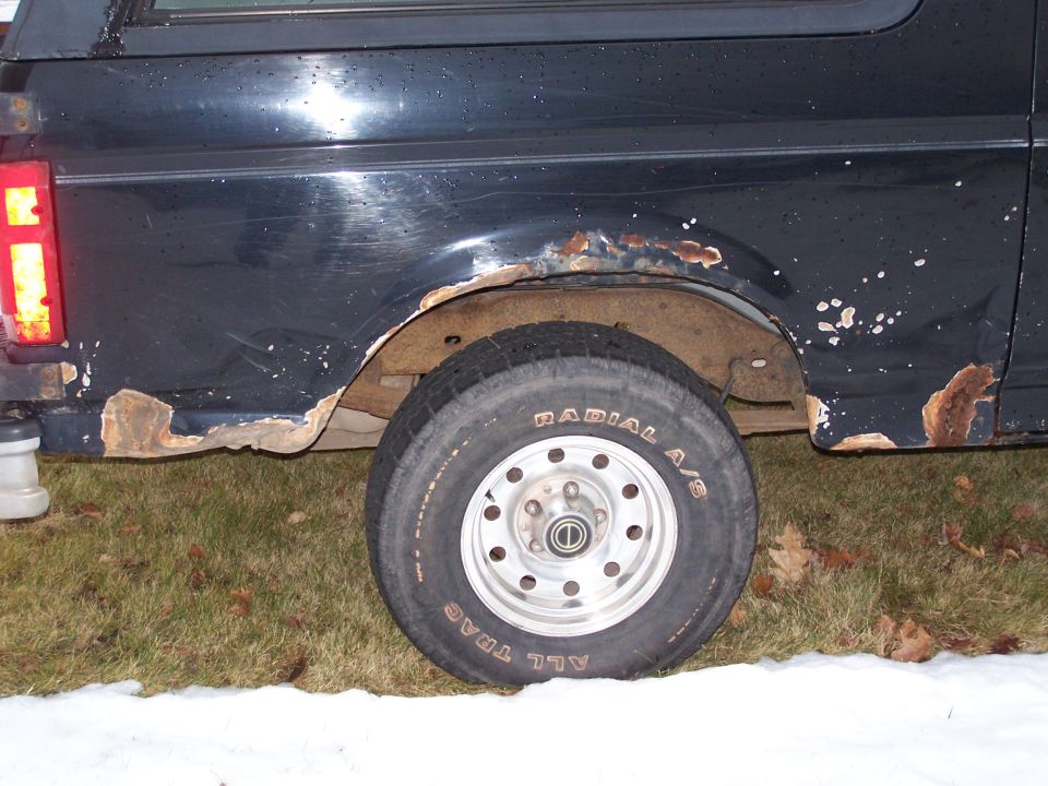 Black 1996 Ford Bronco side view showing rust damage