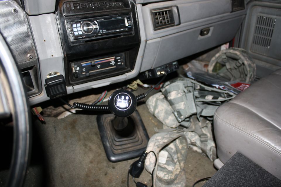 Vehicle interior with gear shift, radio, and camouflage bags