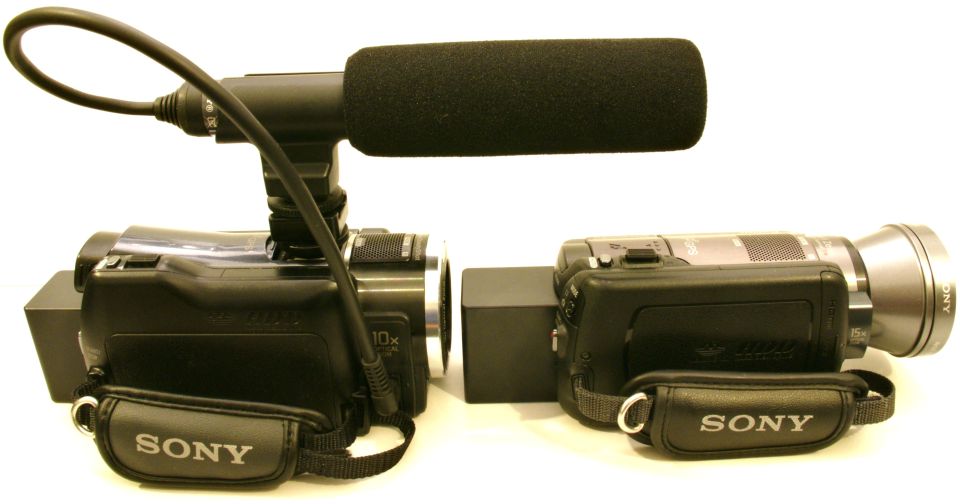 Two Sony camcorders side-by-side, one with a microphone attachment