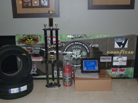 1992 Ford Mustang - A collection of drag racing awards and equipment is displayed, including a trophy and tires.