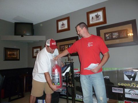 1992 Ford Mustang - Two men are in a room, one holding a fire extinguisher, with trophies and framed pictures visible.