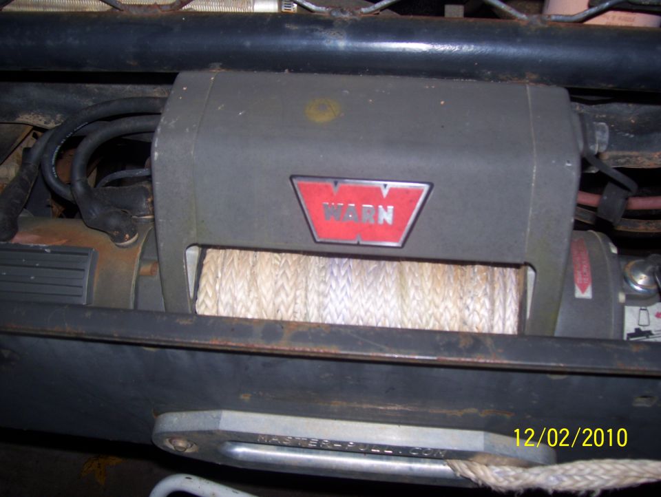 Warn winch mounted on vehicle frame, showing rope spool and red logo