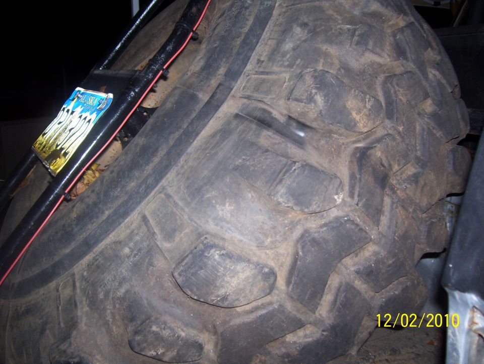 Spare tire mounted with black hardware and a sticker. Date stamp shows 12/02/2010