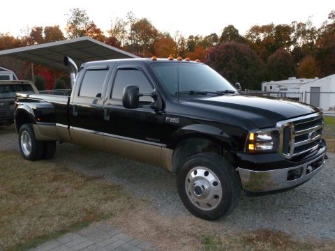 1992 Ford Mustang - This black and tan Ford F-350 Super Duty pickup truck features dual rear wheels and a prominent chrome grille.