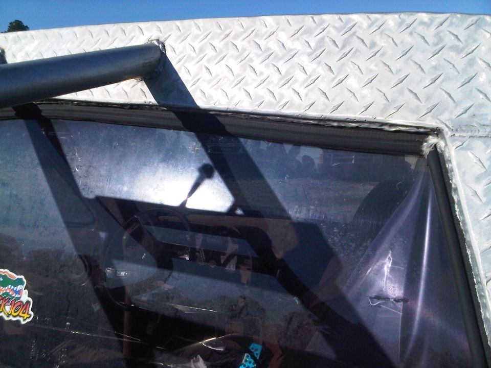 Diamond plate trim above windshield, reflection of steering wheel and shifter visible inside