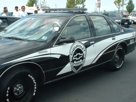 1999 Ford Crown Victoria - This Chevrolet police car has a light bar on the roof and the words "Police Interceptor" on the door.