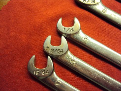 1965 Ford Mustang - A set of fractional inch wrenches are laid out on a red textured surface.