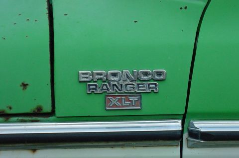 1979 Ford Bronco - The side emblem on this green vehicle reads 'BRONCO RANGER XLT'.