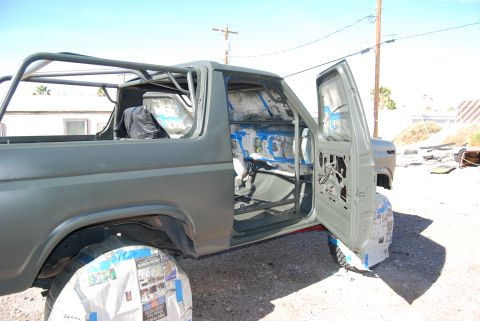 1982 Ford Bronco - This Ford Bronco is being prepped for a new paint job, with its interior protected and a roll cage visible.