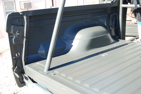 1982 Ford Bronco - Interior of a truck bed, painted gray, with a roll cage installed. Supermotors.net logo is present.