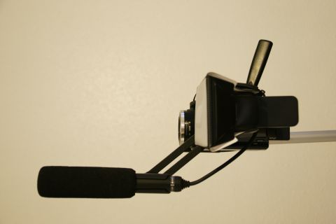 1993 Ford Taurus - A video camera setup with a directional microphone is shown mounted on a pole against a plain wall.