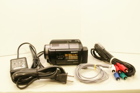 1993 Ford Taurus - A Sony Handycam HDR-XR500V camcorder is displayed with its accessories, including an AC adapter and various cables.