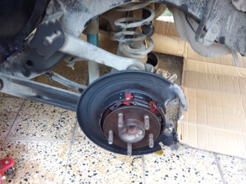 1998 Ford Crown Victoria - Close-up view of a vehicle's rear axle assembly, focusing on the brake components and suspension.