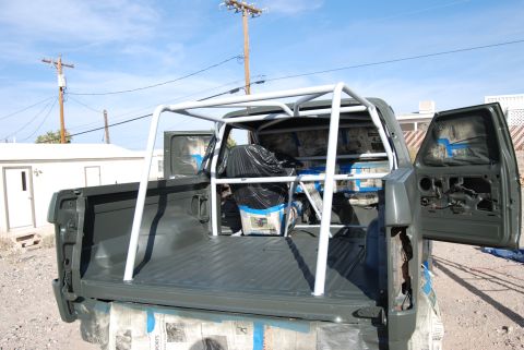 1982 Ford Bronco - Pickup truck bed is being prepped for paint with a roll cage installed and interior covered.