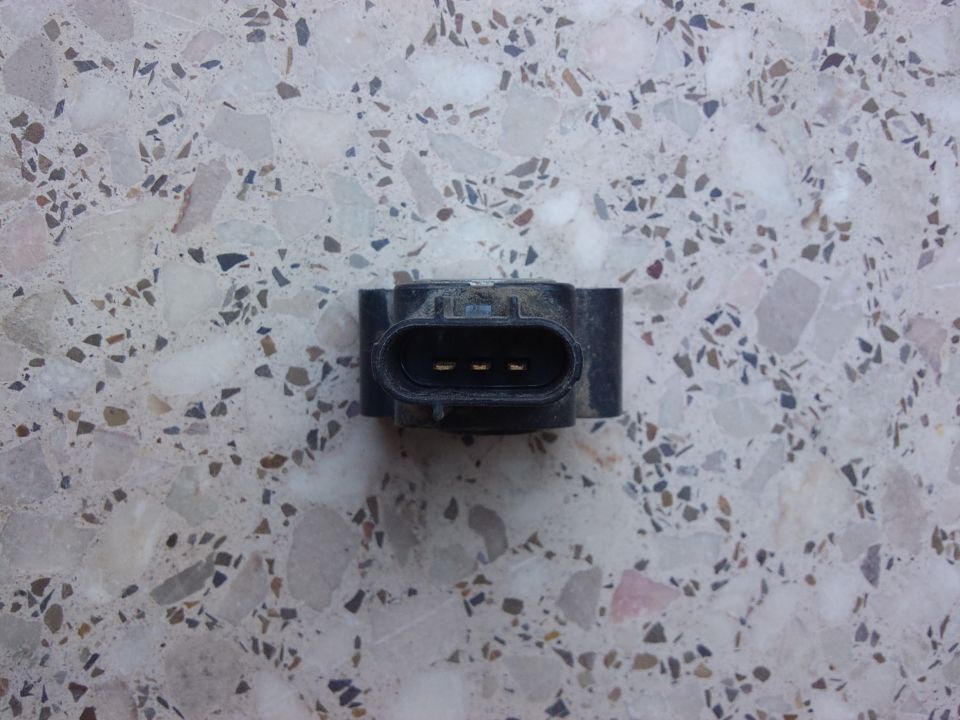Black throttle position sensor with three gold pins visible inside the connector