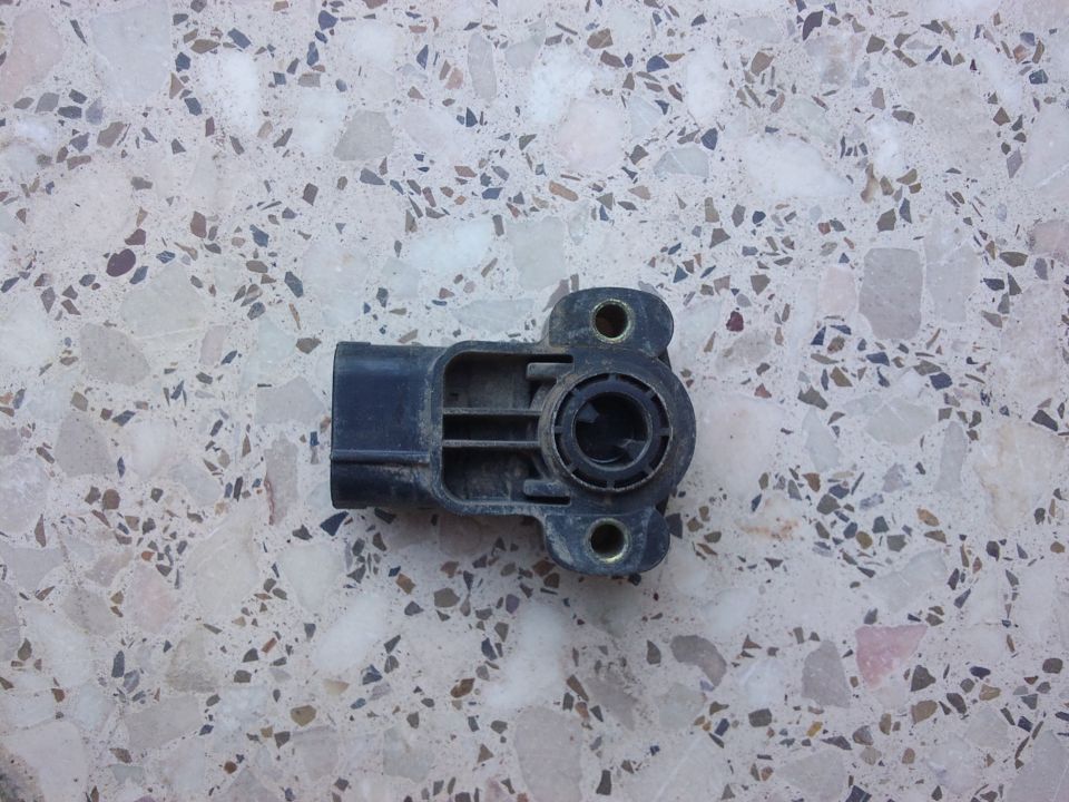 Black throttle position sensor on speckled surface
