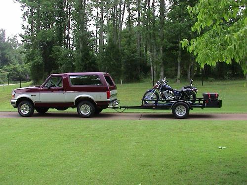 1996 Ford Bronco side view, towing a trailer with a motorcycle