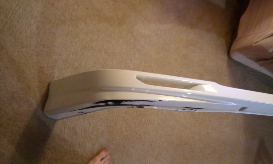 White car bumper part with black markings